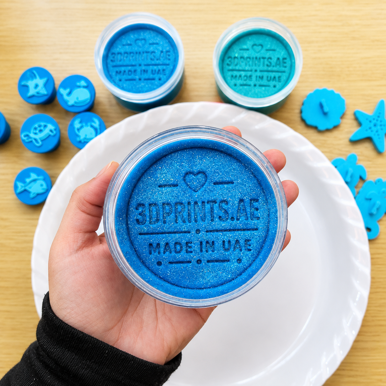 Blue playdough tub made in UAE with ocean tools in the background