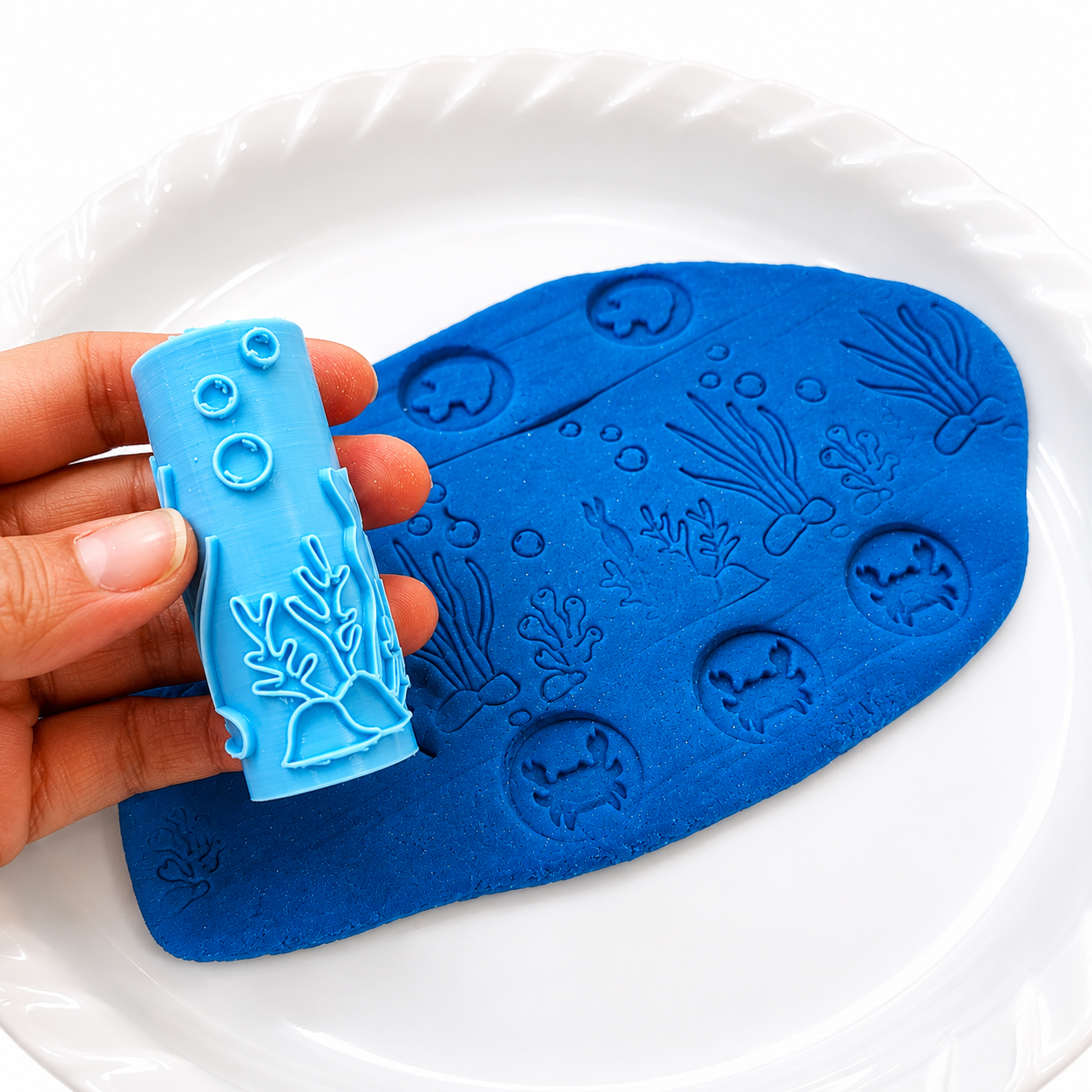 Ocean scene roller creating coral and bubbles in blue playdough