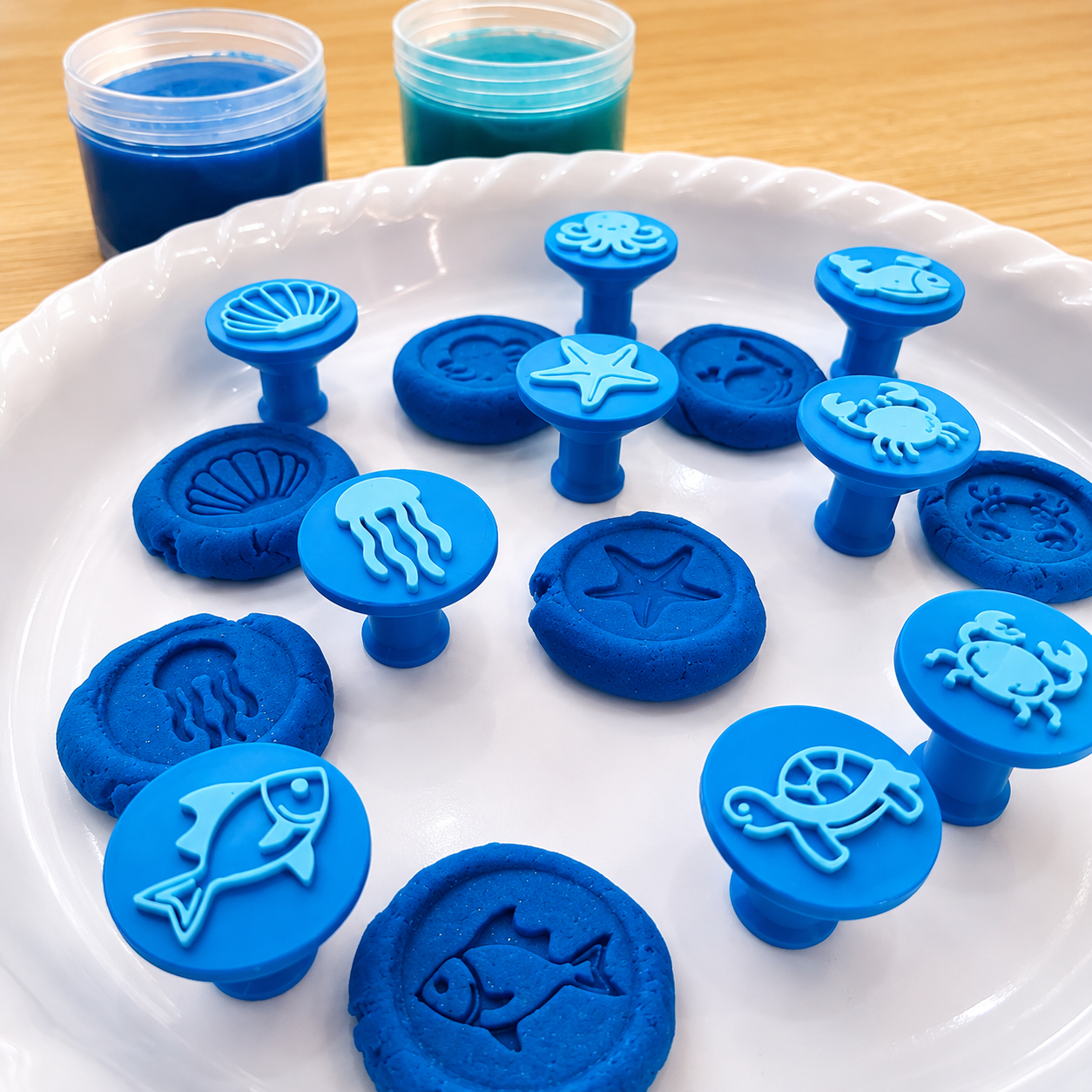 Close-up of ocean animal stamps pressed into blue playdough