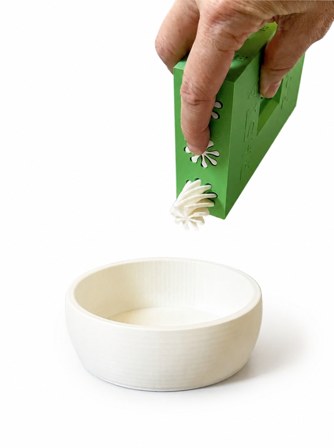 Toy pasta dispenser pouring into a white bowl