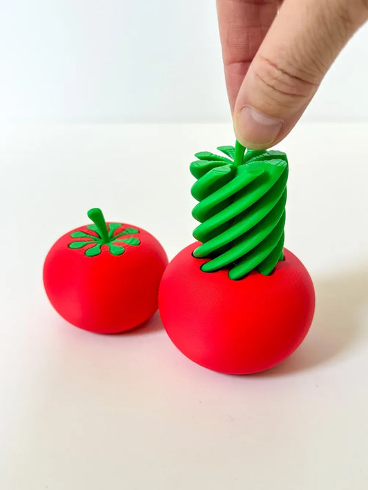 Green twisting insert being placed into the red Tomato Twist toy